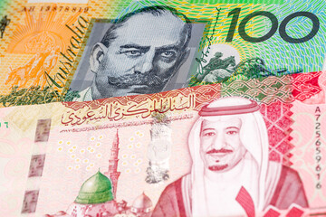 Fototapeta premium 100 Australian dollar and 100 Saudi riyal dollar banknotes. International trade concept
