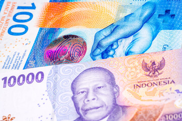 100 Swiss frank and 10000 Indonesian rupee banknotes. International trade concept