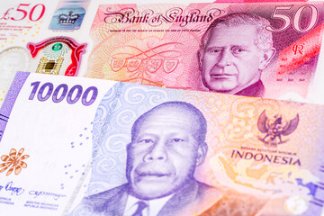 50 British pound and 10000 Indonesian rupee banknotes. International trade concept