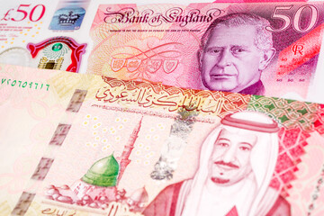 50 British pound and 100 Saudi riyal banknotes. International trade concept