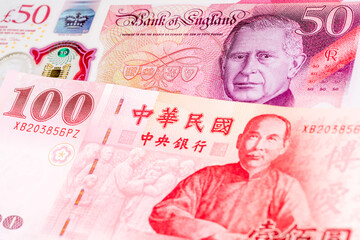 50 British pound and 100 New Taiwan dollar banknotes. International trade concept
