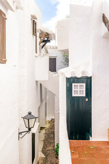 Charming Whitewashed Alley With Dark Green Door and Cobblestone Path in Binibeca Vell. Menorcan Architecture, Traditional Lantern, ideal for travel and design concepts