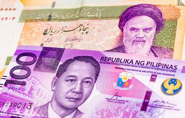 50000 Iranian rial and 100 Philippine Peso banknotes. International trade concept