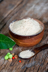 Withania somnifera (Ashwagandha) dried root Powder, green leaves Medicinal Herb. Ashwagandha on wooden background