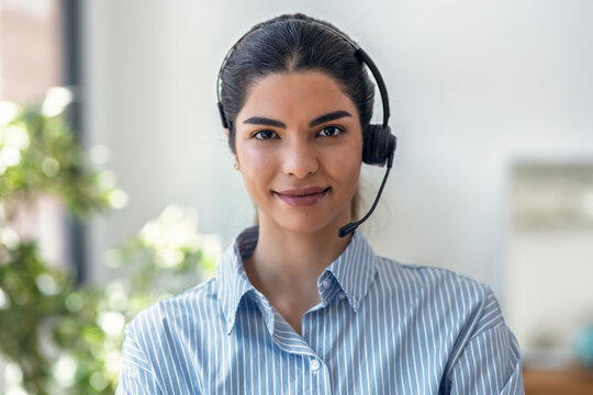 Smiling customer service representative using a headset in an office