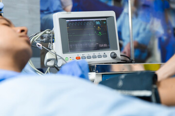 Patient in hospital bed connected to a medical device monitoring vital signs