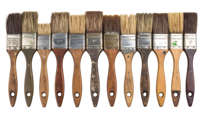 A row of 13 paintbrushes with wooden handles and bristles of varying widths and colors lined up side by side.