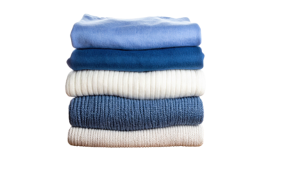 A neatly stacked pile of five folded sweaters in various shades of blue and white.