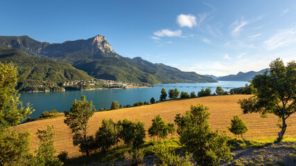 Summer panoramic view of Serre-Poncon Lake with Savines-le-Lac village, its bridge and the Grand...