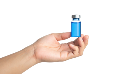 A hand holds a small vial filled with a blue liquid against a black background.