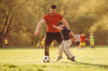 Game of soccer. Father and son are having fun outdoors