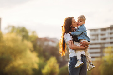 Warm sunlight. Mother and son are together on the summer field