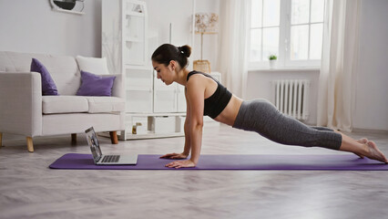 Obraz premium A woman holding a plank position on a yoga mat, with a focus on her physique and posture