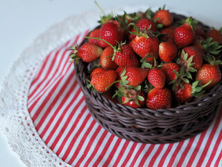 Ripe red strawberry in basket on tablecloth
