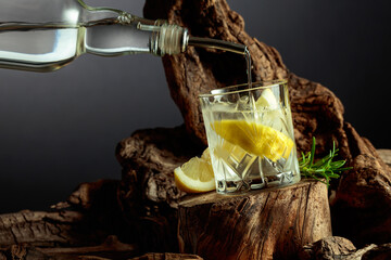 Cocktail gin and tonic with lemon slices and sprig of rosemary.