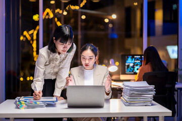 Asian businesswomen working late using laptop in office at night
