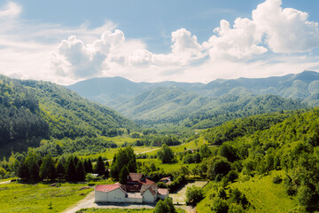 Breathtaking panorama of green valley surrounded by majestic mountains on sunny day
