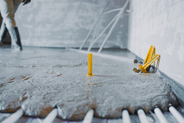 Obraz na płótnie Canvas Construction worker pouring concrete surface flooring over underfloor heating system
