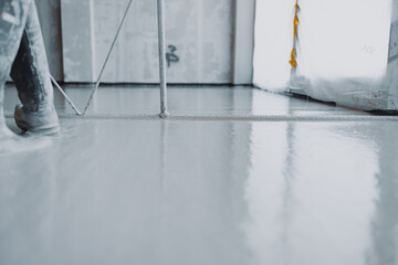 Construction worker leveling concrete surface flooring using specialized tool