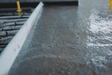 Workers pouring and finishing concrete surface flooring