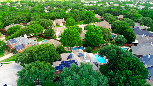 Aerial view lush green homes with rooftop solar panel arrays, angled installations for optimal sunlight capture, supporting clean efficiency energy, lower bills, sustainable, DFW metroplex, Texas