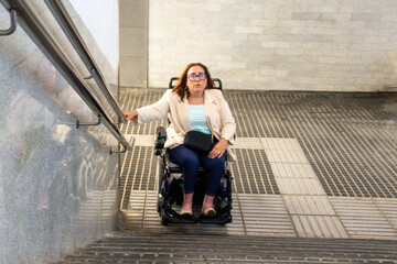 Businesswoman in wheelchair using ramp in subway station. Concept of inclusion, adapted public