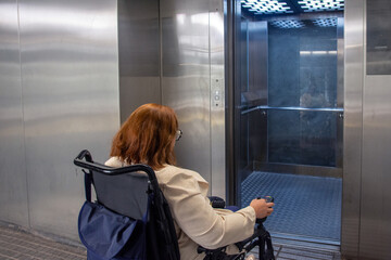 Woman in wheelchair operating elevator in subway station. Concept of inclusion, adapted public
