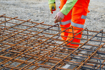Construction worker steel fixer assembling rebar at building site
