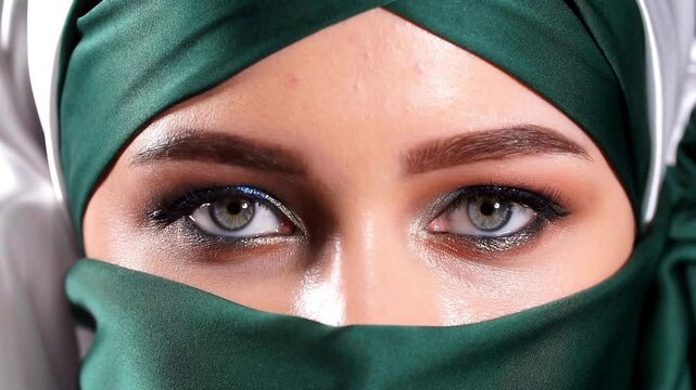 Slow Motion, 120 fps. Young Woman with hijab niqab is opening and closing her beautiful eye. macro beauty eye opening looking scared blinking healthy eyesight close up
