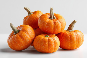 A charming pile of miniature, vibrant orange gourds with distinctive stems, ready for seasonal decor or culinary use, isolated on a clean, bright background.

