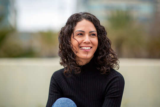 Portrait young woman smiling and looking away outdoors in urban setting