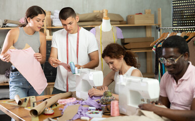Diverse group of adults beginners working with fabric, paper patterns, and sewing tools in hands-on learning environment focused on garment design and construction