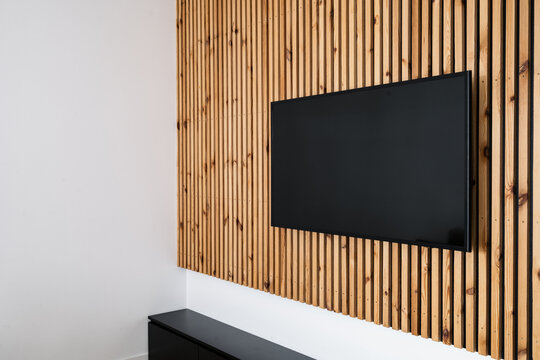Modern living room with sleek LCD television mounted on wooden wall panel