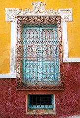 Blue wooden window with wrought iron lattice in Chinchilla de Montearagon