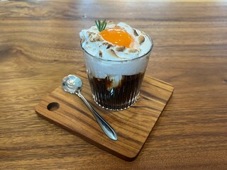 Black coffee with whipped egg white foam, finished with an egg yolk on top