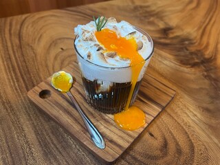 Black coffee with whipped egg white foam, finished with an egg yolk on top