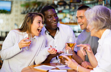 Happy friends drinking beer and chatting with each other in a restaurant