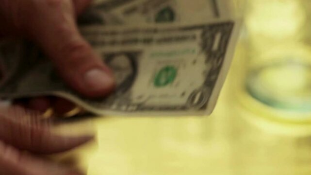 Dollar bills in hands close-up. Money in hand. a man counts dollar bills for his investments. Closeup of hands counting dollar bills.