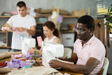Sewing teacher watches students, gives recommendations, instructions, shares experience, helps to...