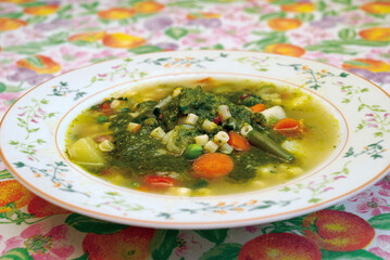 Minestrone soup with pesto and mixed vegetables served in a bowl