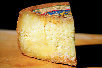 Slice of seasoned cheese resting on wooden cutting board