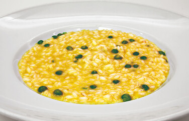 Saffron risotto with green peppercorns served in white plate