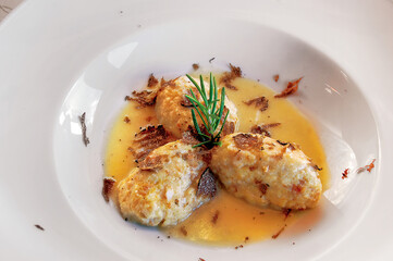 Potato gnocchi with truffle and rosemary lying in a white dish