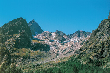 Melting glacier flowing down a mountain chain in the Alps