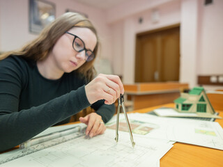 Caucasian young woman making drawings. Student of architecture university. 
