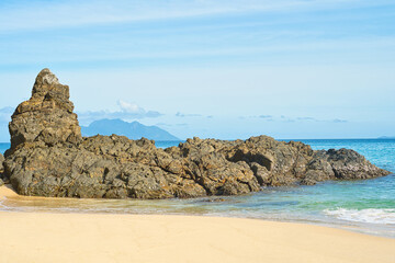 Beautiful beach of Sunset, volcanic stones, transparant and turqouise water, with silhouette island...