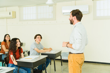 High school teacher giving lesson to students in classroom