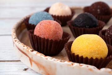 Candies made from dried fruits and nuts on a ceramic plate. Healthy dessert with different flavors