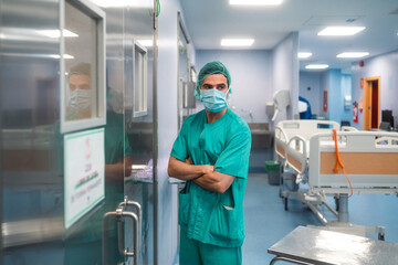 Surgeon in green scrubs waiting outside the operating room
