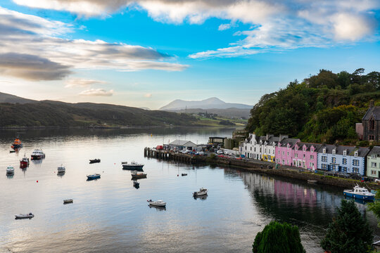 Vibrant, colorful cottages line the waterfront in Portree, Isle of Skye, with boats in the calm harbor